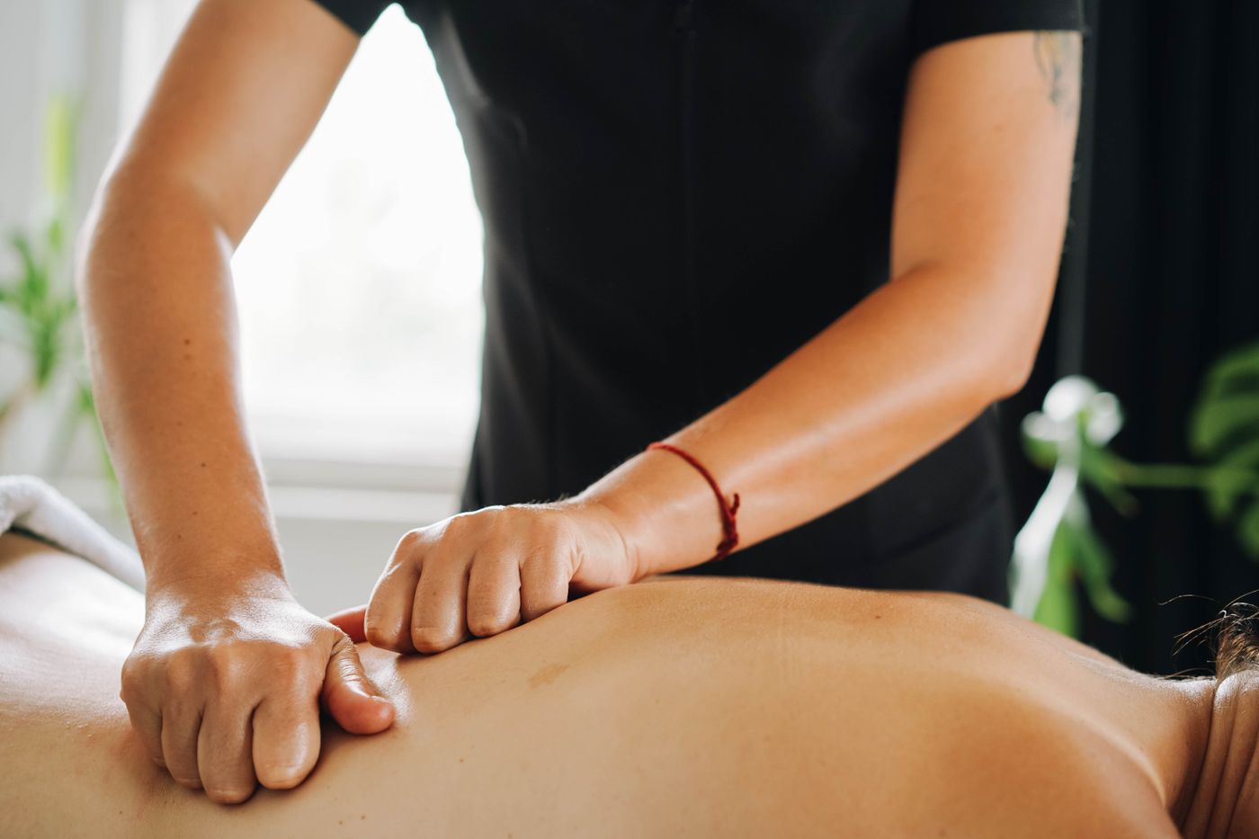 Terapis memberikan tekanan pijat deep tissue pada punggung klien